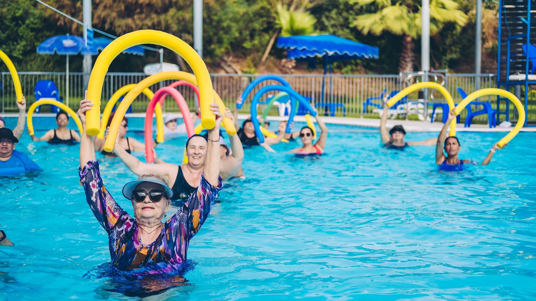 Women in their senior years are exercising in the pool.