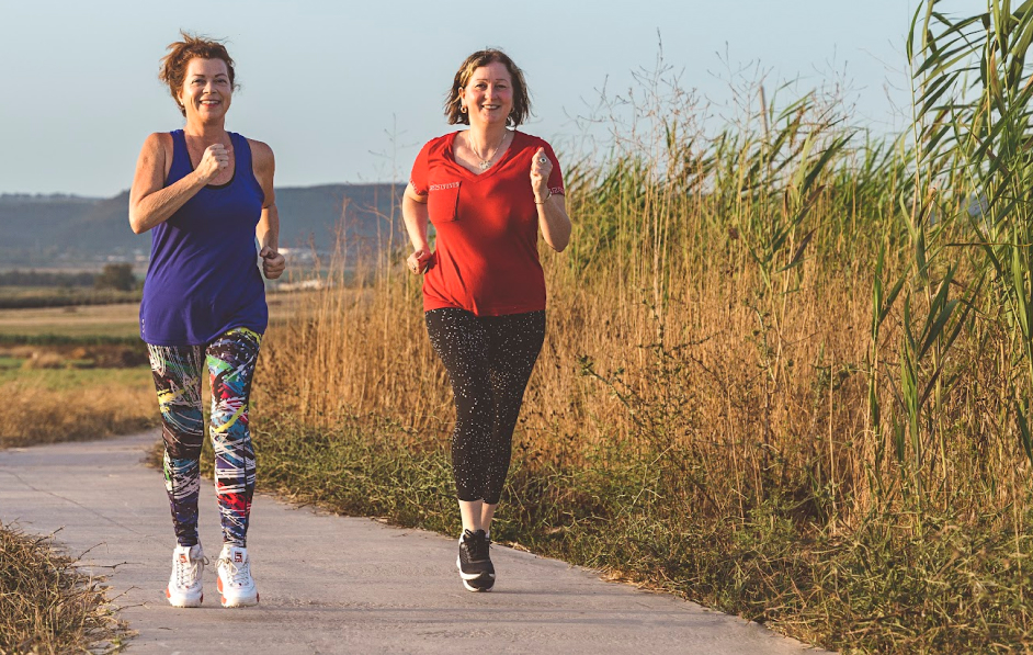 Two women jogging in workout clothing