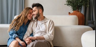 גבר ואישה יושבים על ספה ואוחזים ידיים