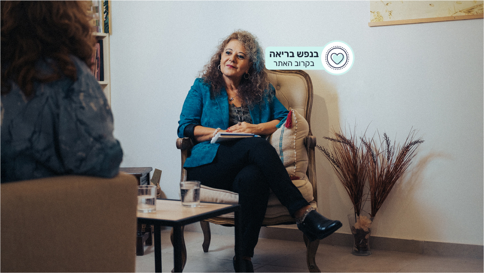 אישה יושבת על כורסא ומשוחחת עם אישה אחרת שיושבת מולה, ואייקון "בנפש בריאה בקרוב האתר!"