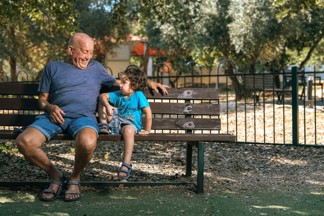 גבר בגיל השלישי וילד יושבים על ספסל