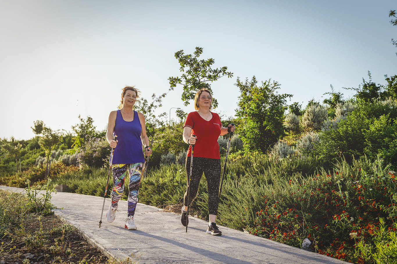 Two women are walking on a path.